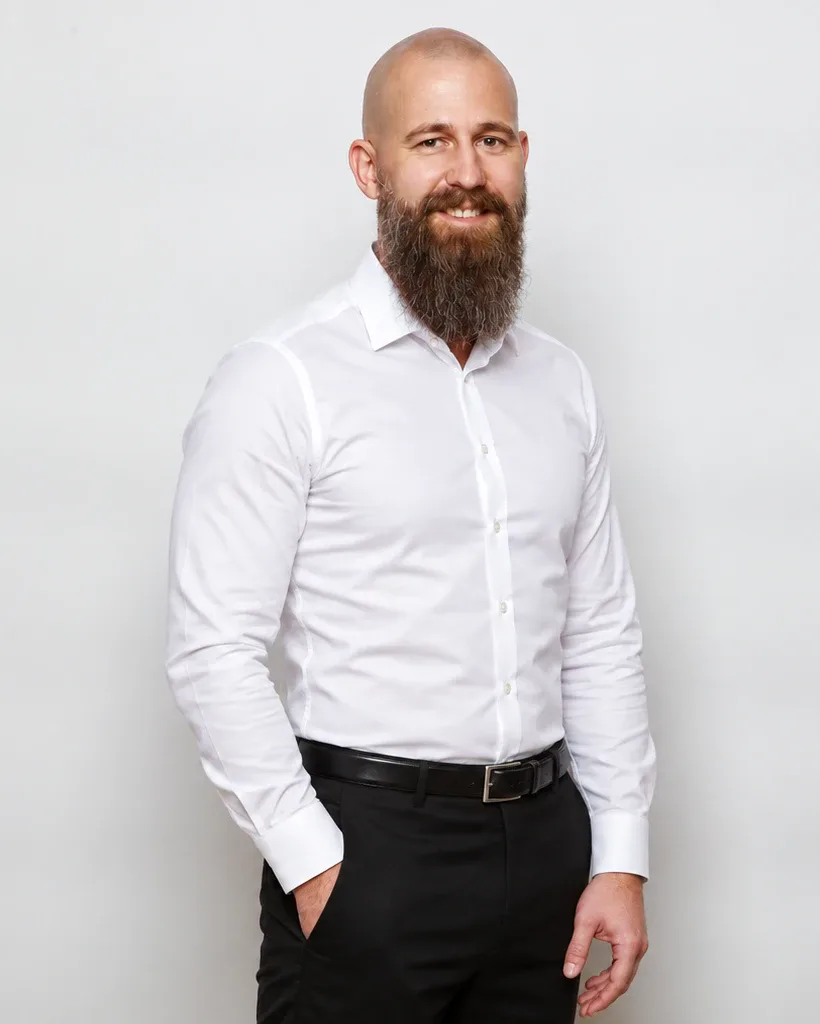 Florian Muff im weissen Hemd vor hellgrauem Hintergrund